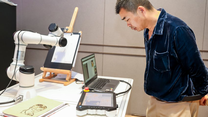 嘉賓體驗(yàn)遨博AI繪畫機(jī)器人。主辦方供圖